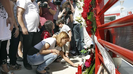 Una mujer coloca una vela, durante un homenaje a las doce personas que fallecieron Una mujer coloca una vela, durante un homenaje a las doce personas que fallecieron