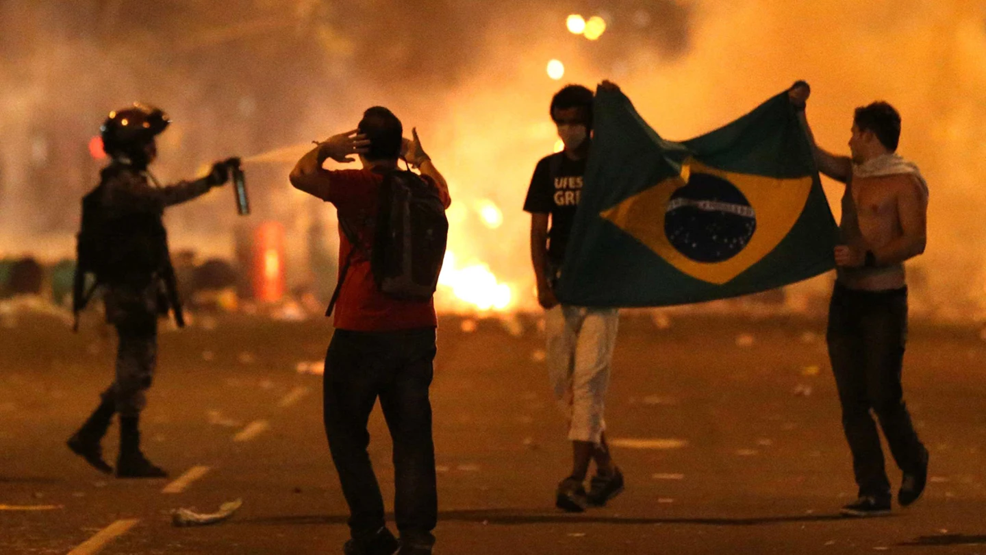 Tres manifestantes con un bandera brasileña participan en una protesta en Niterói Tres manifestantes con un bandera brasileña participan en una protesta en Niterói