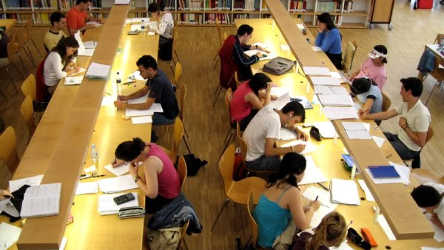 Estudiantes en una biblioteca Estudiantes en una biblioteca