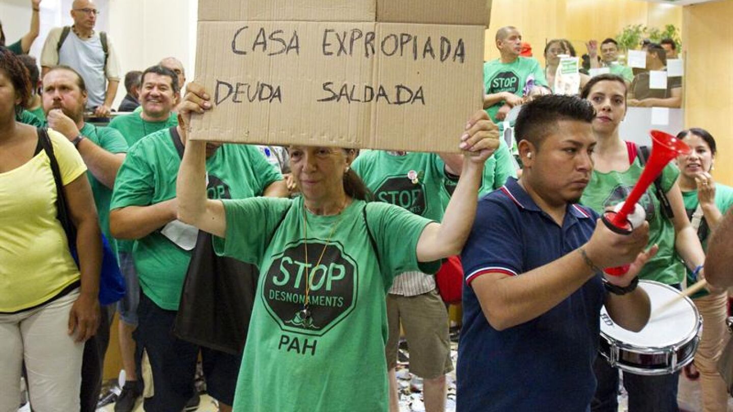 Varios miembros de la PAH se concentran frente a una sucursal de Catalunya Caixa