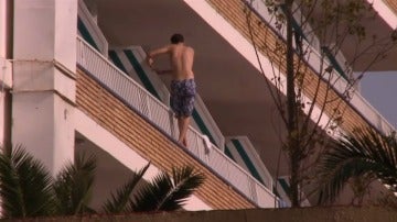 Un turista intentando saltar de un balcón a otro.