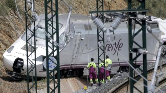 Varios operarios trabajan cerca de la locomotora