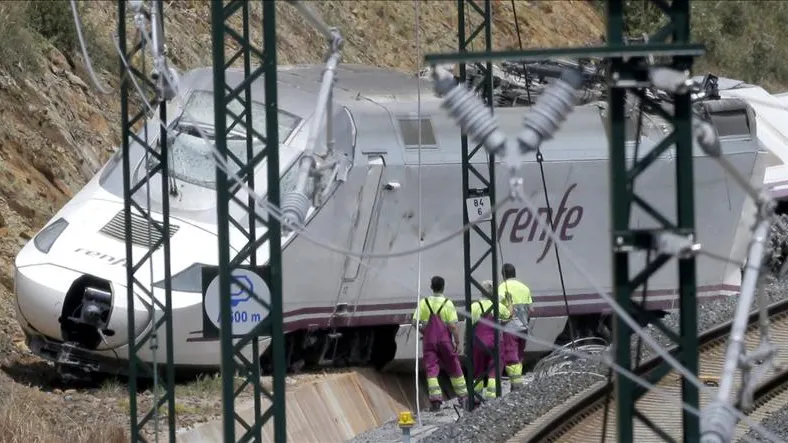 Varios operarios trabajan cerca de la locomotora
