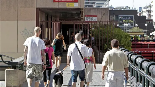 Varias personas llegan a una oficina de empleo Varias personas llegan a una oficina de empleo