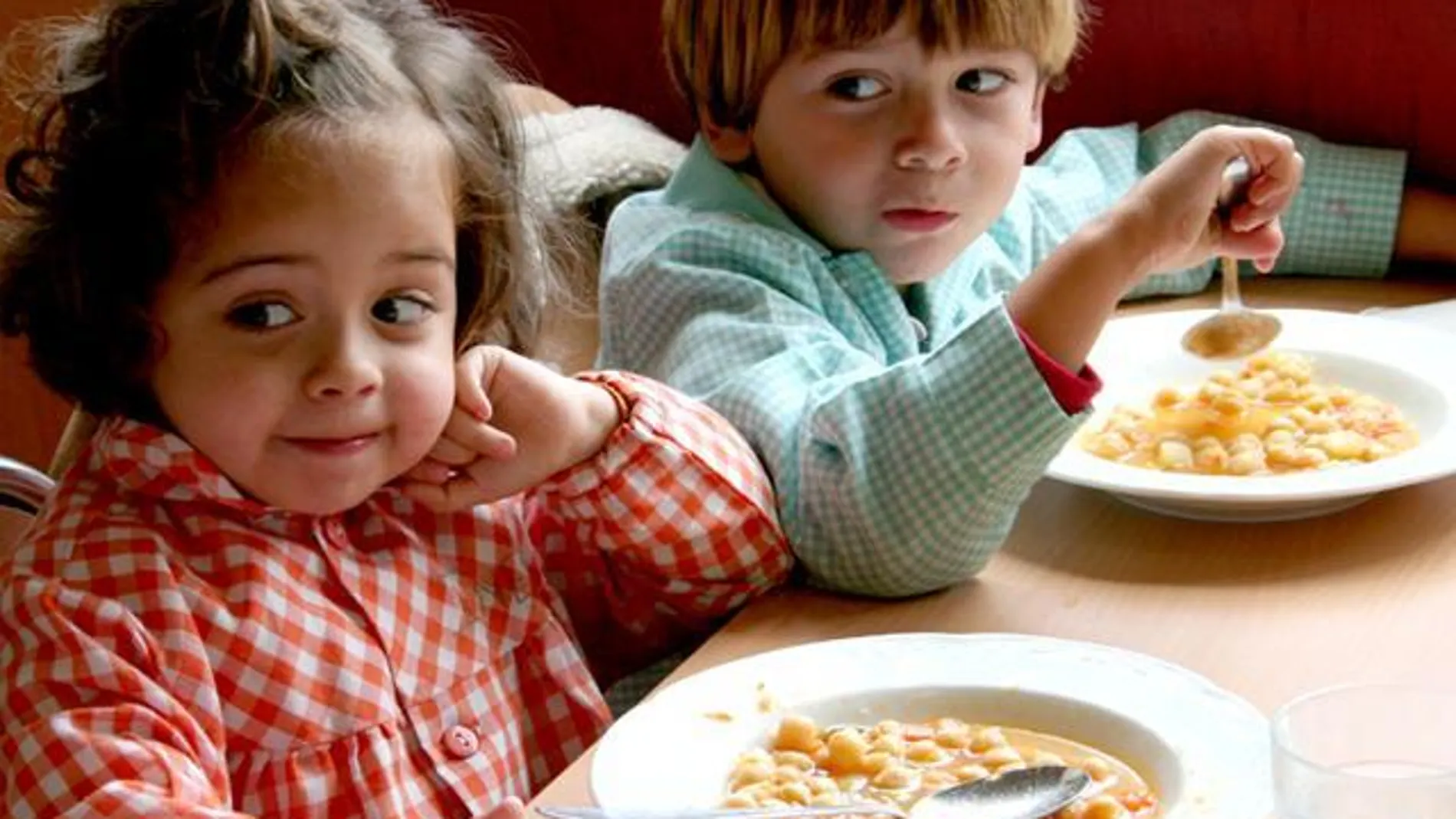 Dos niños comen garbanzos