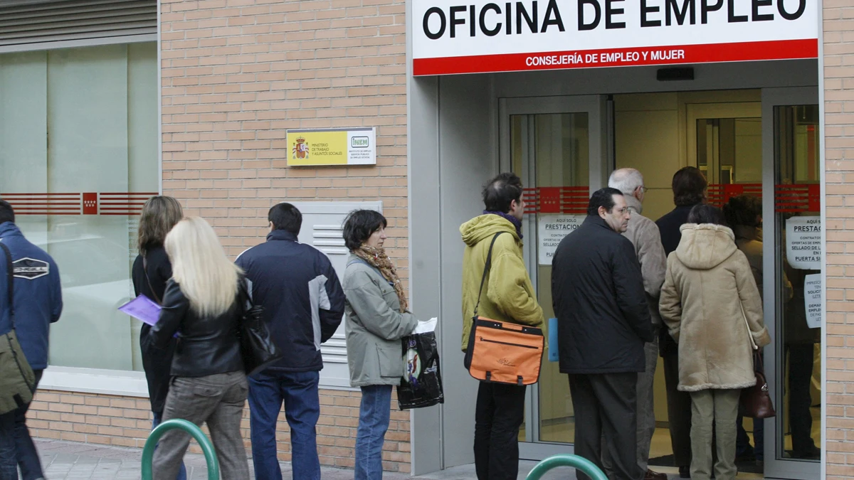 Un grupo de personas hacen cola en una oficina de empleo.