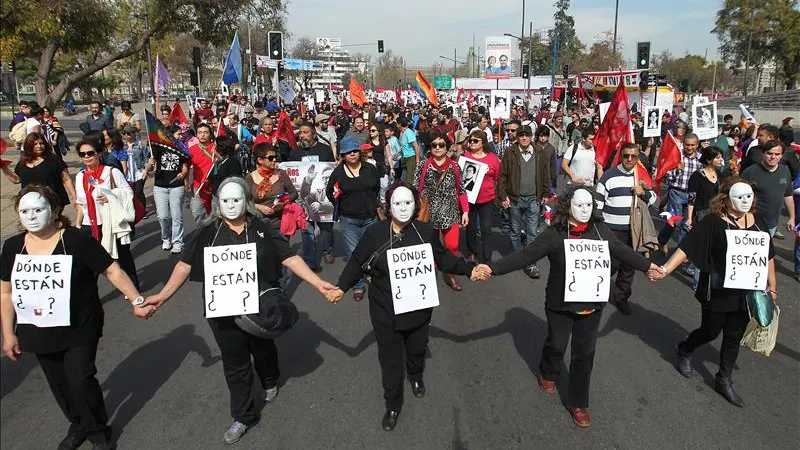 Miles de personas con fotografías de desaparecidos marchan en conmemoración del 40 aniversario del golpe de Pinochet 