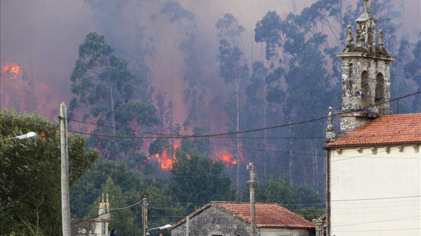 Varios vecinos observan el humo del incendio de Figueiras