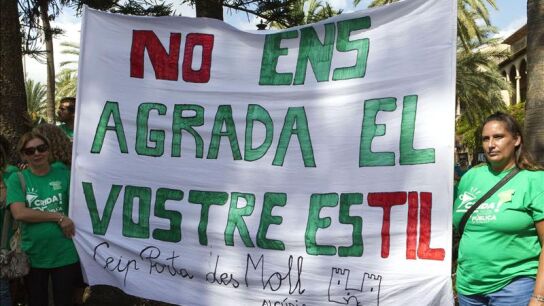 Dos mujeres sostienen una pancarta que hace alusi&oacute;n a los recortes en educaci&oacute;n