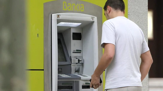 Un hombre saca dinero de un cajero automático. Un hombre saca dinero de un cajero automático.