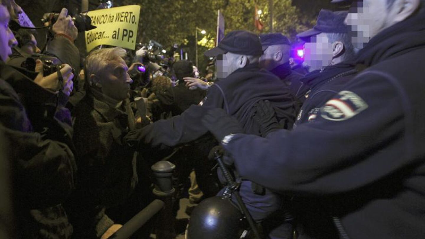 Agentes de la polic&iacute;a ante los concentrados esta tarde ante la sede del PP