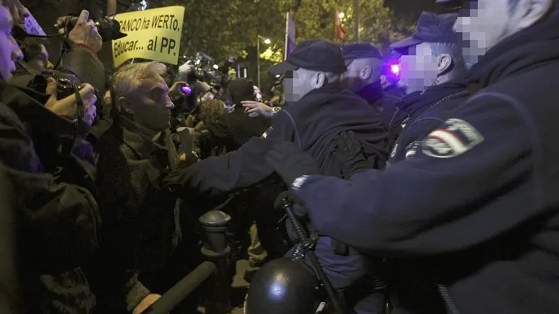 Agentes de la policía ante los concentrados esta tarde ante la sede del PP