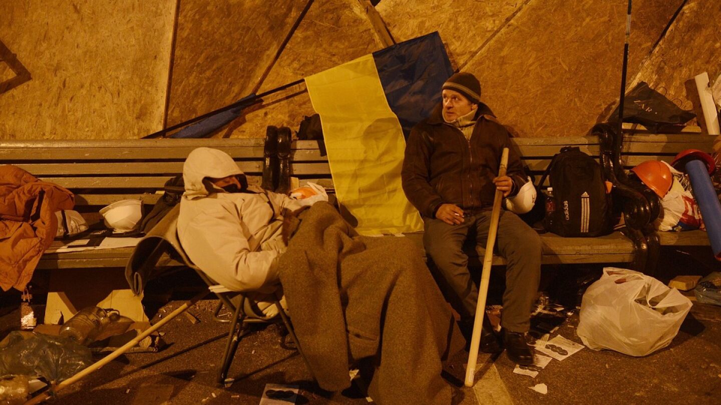 Manifestantes descansan junto a una barricada