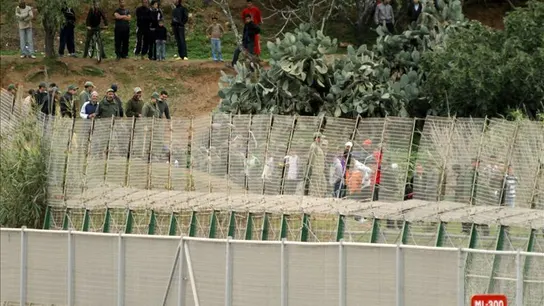 Varias personas junto a la valla de Melilla Varias personas junto a la valla de Melilla