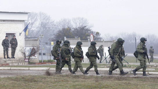 Soldados ucranianos observan a un grupo de militares armados uniformados 