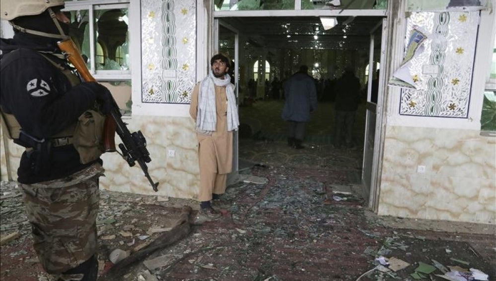 Un agente de policía afgano vigila la entrada de un seminario islámico