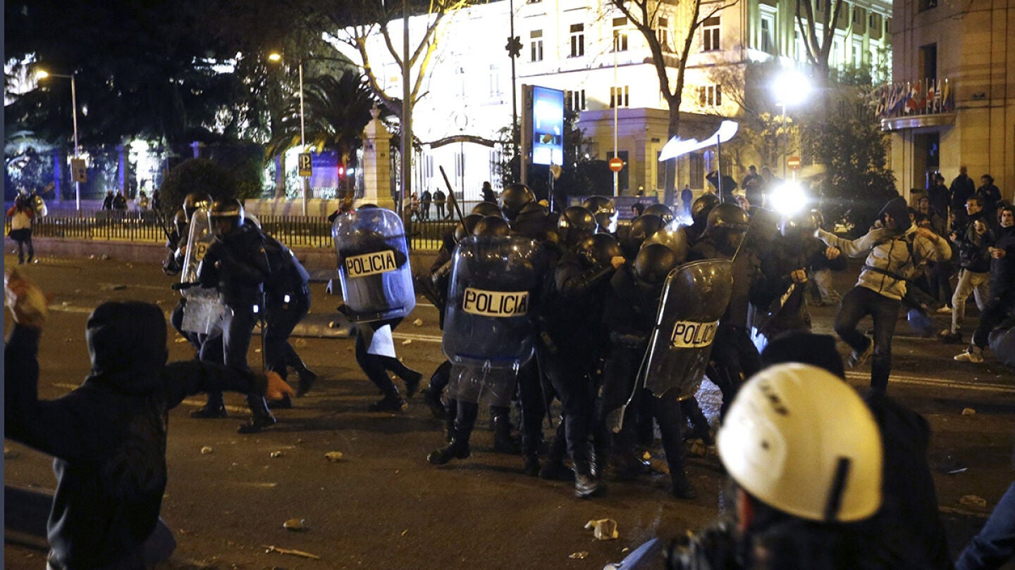  Un joven lanza un objeto a diversos agentes de la polic&iacute;a antidisturbio al t&eacute;rmino del 22M