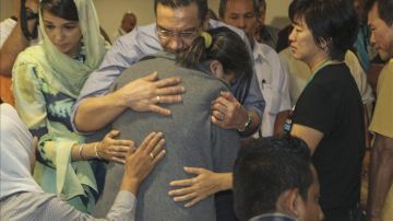 El ministro malasio de Defensa, Hishamuddin Hussin, consuela a un familiar de uno de los pasajeros