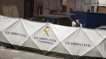 Agentes de la Guardia Civil junto a la vivienda de la localidad madrileña de Villarejo de Salvanés