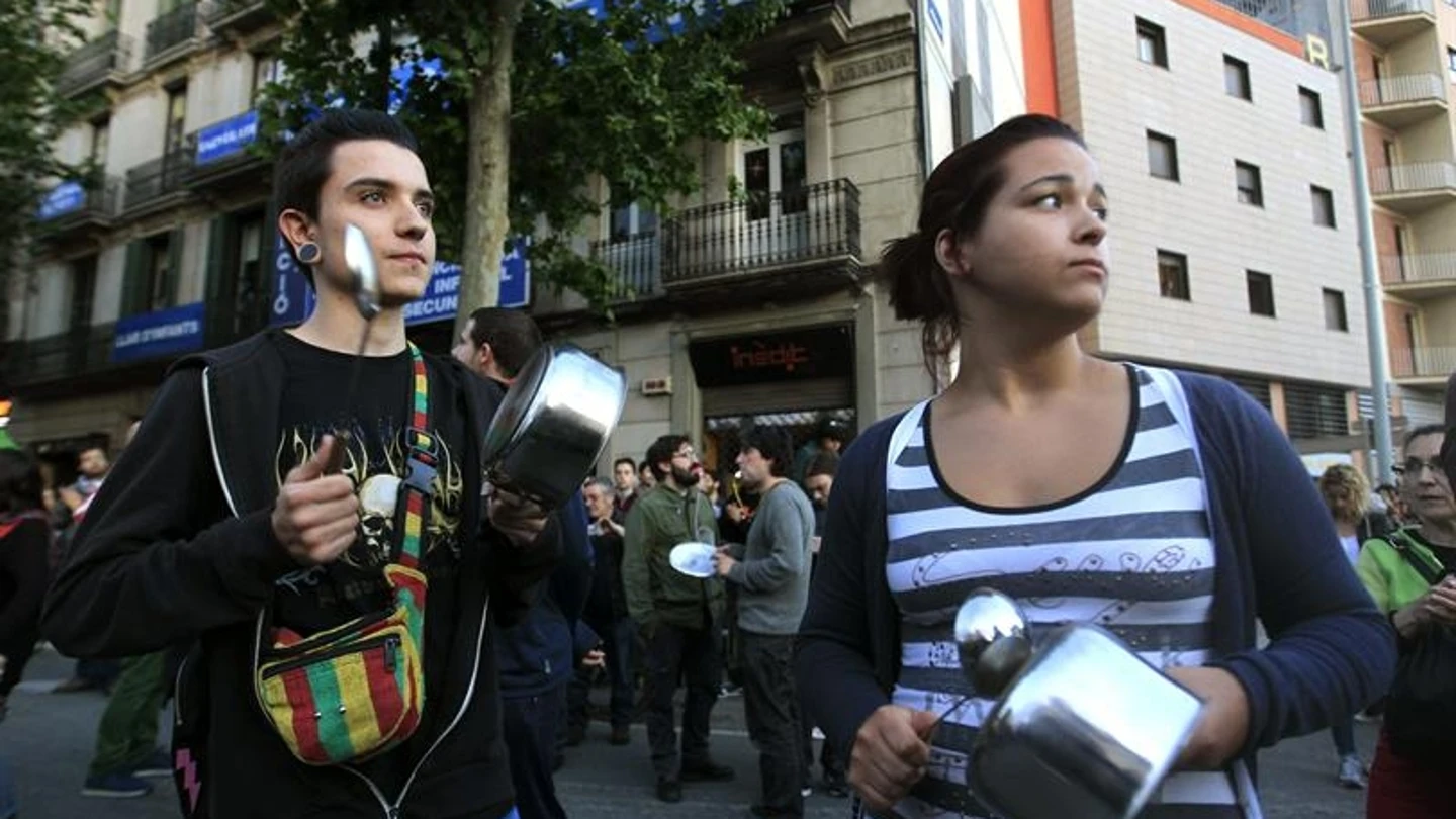 Dos jóvenes durante la cacerolada en el barrio de Sants Dos jóvenes durante la cacerolada en el barrio de Sants