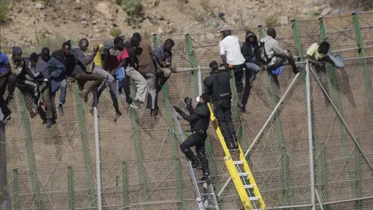 Inmigrantes sobre la valla de Melilla Inmigrantes sobre la valla de Melilla