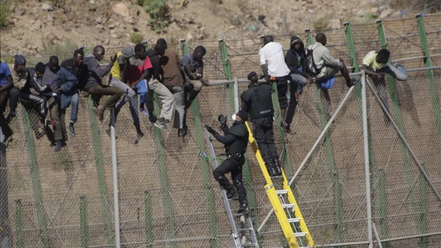 Inmigrantes sobre la valla de Melilla Inmigrantes sobre la valla de Melilla