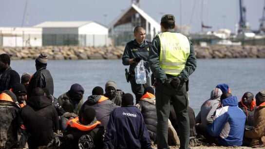 Dos miembros de la Guardia Civil junto al grupo de 25 inmigrantes