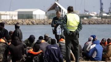 Dos miembros de la Guardia Civil junto al grupo de 25 inmigrantes