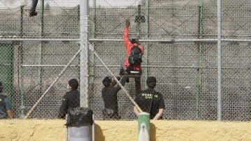 Varios inmigrantes de origen subsahariano encaramados a la valla de Melilla