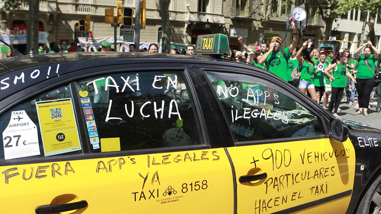 Un taxi de Barcelona pintado con varios lemas durante una manifestaci&oacute;n contra Uber