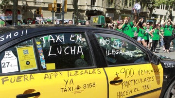 Un taxi de Barcelona pintado con varios lemas durante una manifestación contra Uber