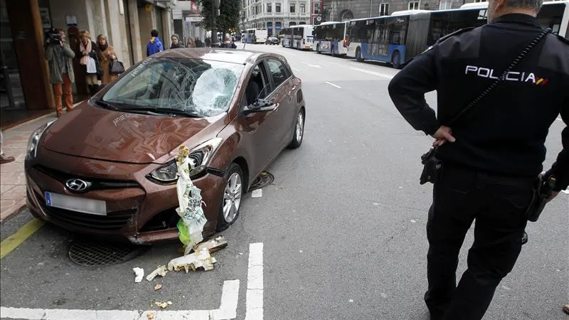 Un miembro de la Policía Nacional junto al vehículo que arrolló a varios peatones