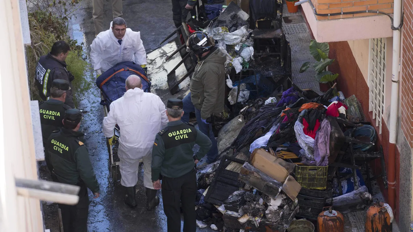 Efectivos de los servicios funerarios trasladan el cuerpo de uno de los tres fallecidos en el incendio. Efectivos de los servicios funerarios trasladan el cuerpo de uno de los tres fallecidos en el incendio.