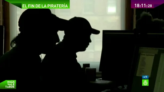 Dos siluetas usan un ordenador Dos siluetas usan un ordenador