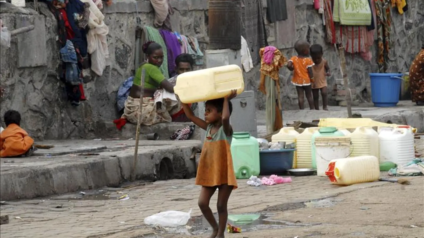 Una niña huérfana carga con un bidón para el agua en Bombai (India). Una niña huérfana carga con un bidón para el agua en Bombai (India).