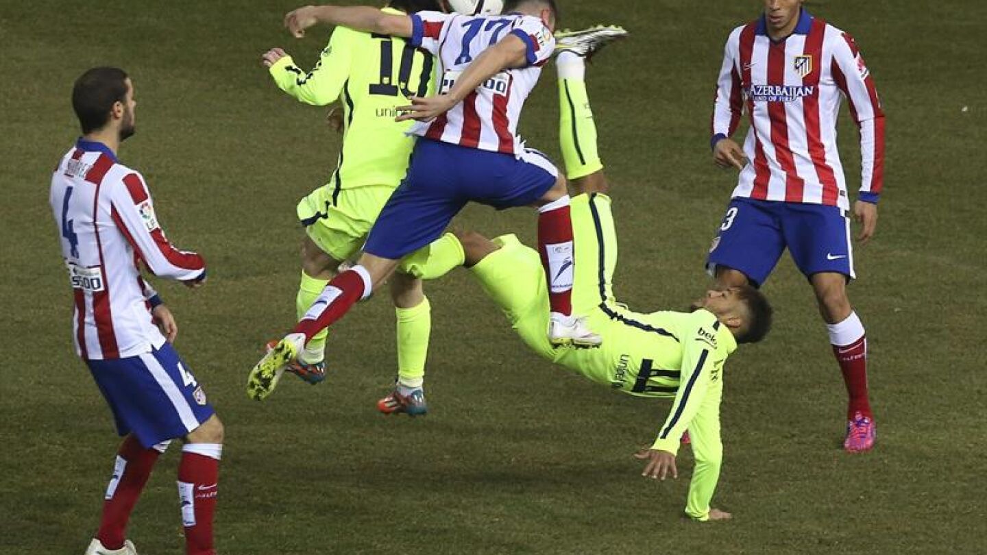 Futbolistas de Atleti y Bar&ccedil;a disputan un bal&oacute;n
