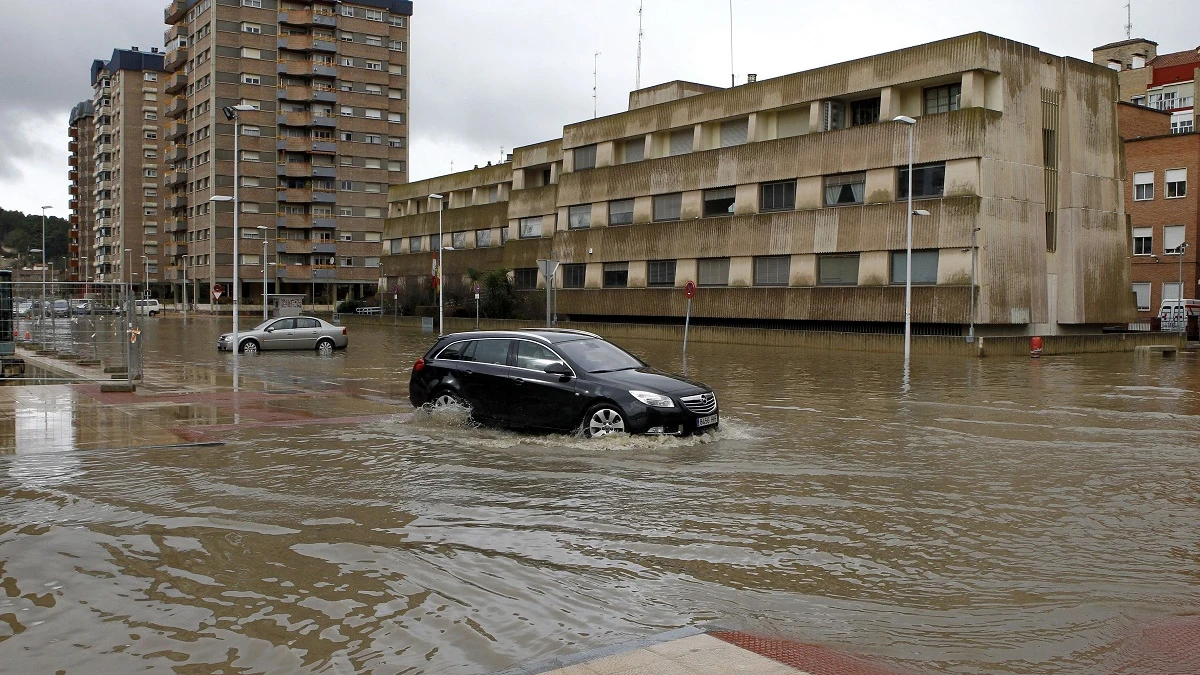 Un vehículo intenta circular en Miranda de Ebro, debordada tras la crecida del río Ebro. 