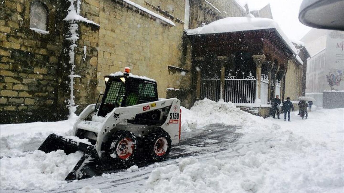 Un operario retira la nieve acumulada en una de las calles de la localidad oscense de Jaca