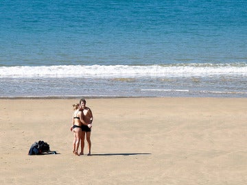Una pareja disfruta del sol en la playa de La Concha de San Sebastián