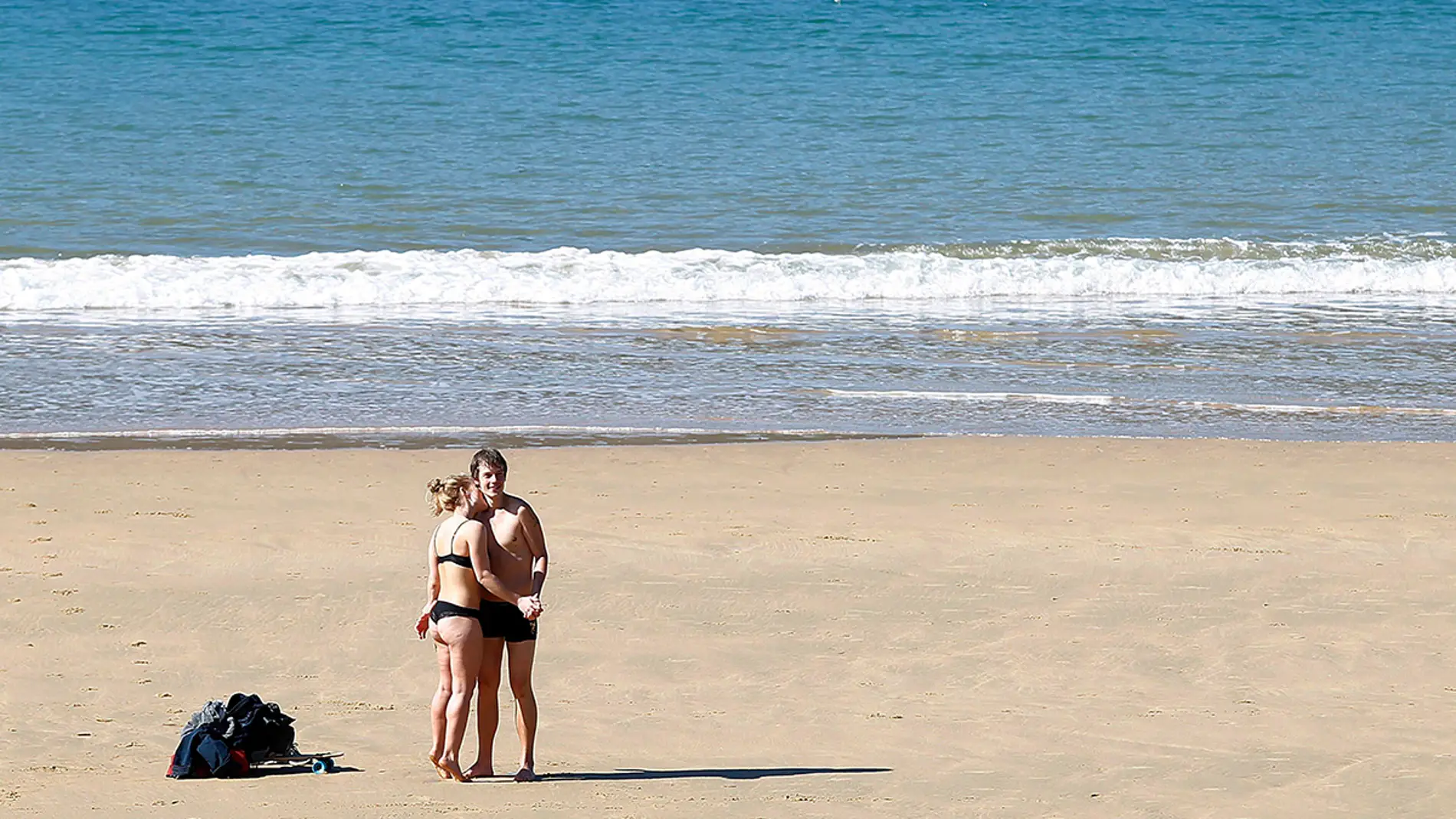 Una pareja disfruta del sol en la playa de La Concha de San Sebastián