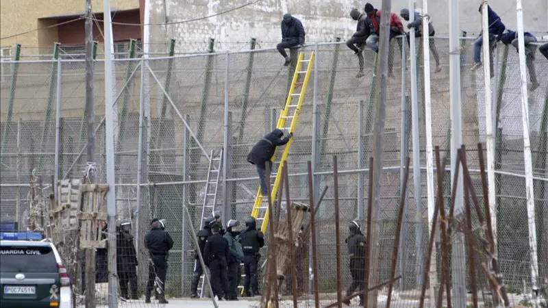 ARCHIVO Varios inmigrantes en la valla de Melilla 