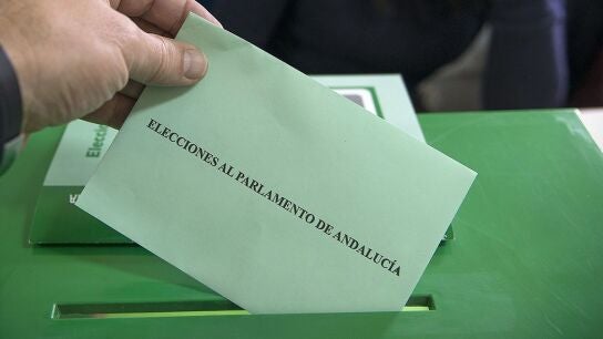 Un votante introduce su papeleta en la urna en un colegio electoral de Ja&eacute;n