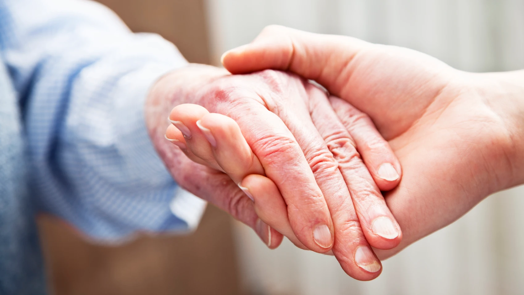 Manos entrelazadas de una anciana y una joven (Archivo) Manos entrelazadas de una anciana y una mujer (Archivo)