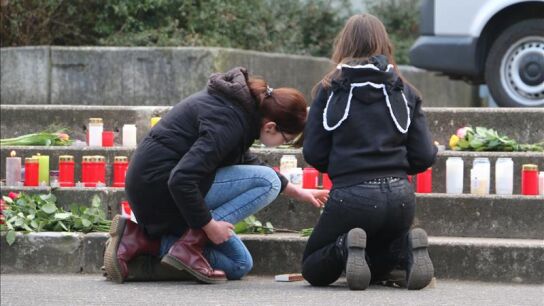 Dos j&oacute;venes encienden velas por las v&iacute;ctimas del avi&oacute;n accidentado
