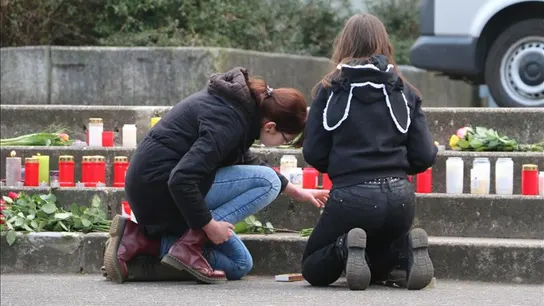 Dos jóvenes encienden velas por las víctimas del avión accidentado Dos jóvenes encienden velas por las víctimas del avión accidentado