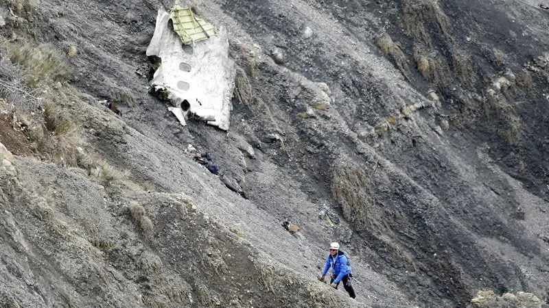 Un miembro de los servicios de rescate al lado de un resto fuselaje 