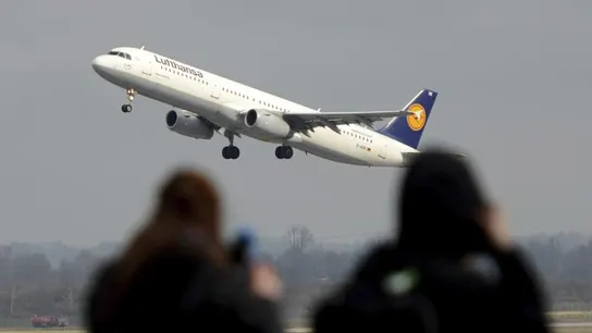 Un avión de Lufthansa sobrevuela dos personas Un avión de Lufthansa sobrevuela dos personas
