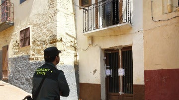 Un efectivo de la Guardia Civil observa la vivienda incendiada de Ejea de los Caballeros