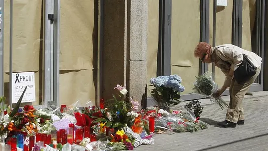 Una mujer deposita flores en el instituto Joan Fuster. Una mujer deposita flores en el instituto Joan Fuster.