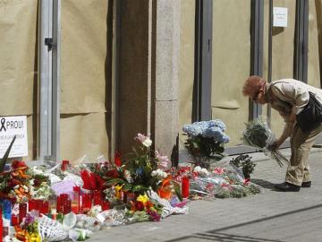 Una mujer deposita flores en el instituto Joan Fuster. Una mujer deposita flores en el instituto Joan Fuster.